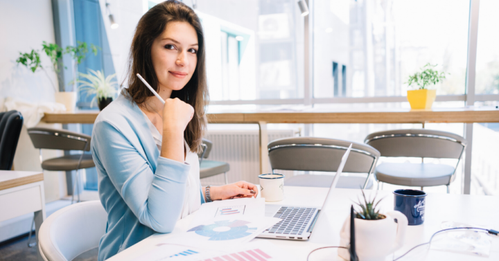 Девушка пишет в ежедневнике, ставя галочки напротив выполненных задач